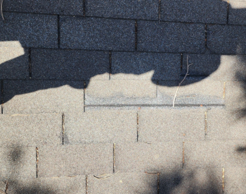 Professional roofer conducting a roof inspection in Macomb County, MI.