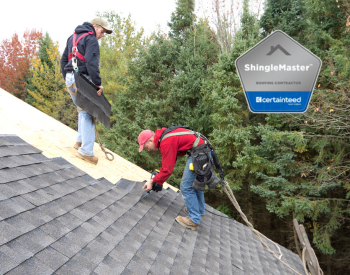 Professional roofers installing new shingles on a Rochester roof in preparation for the fall.