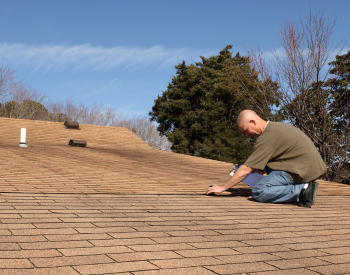 Roofer in Rochester conducting a fall roof inspection on a residential home.