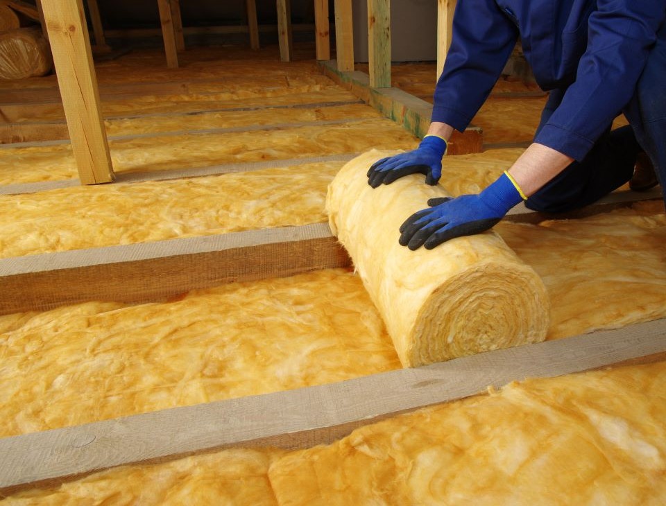 Insulation being unrolled in home attic